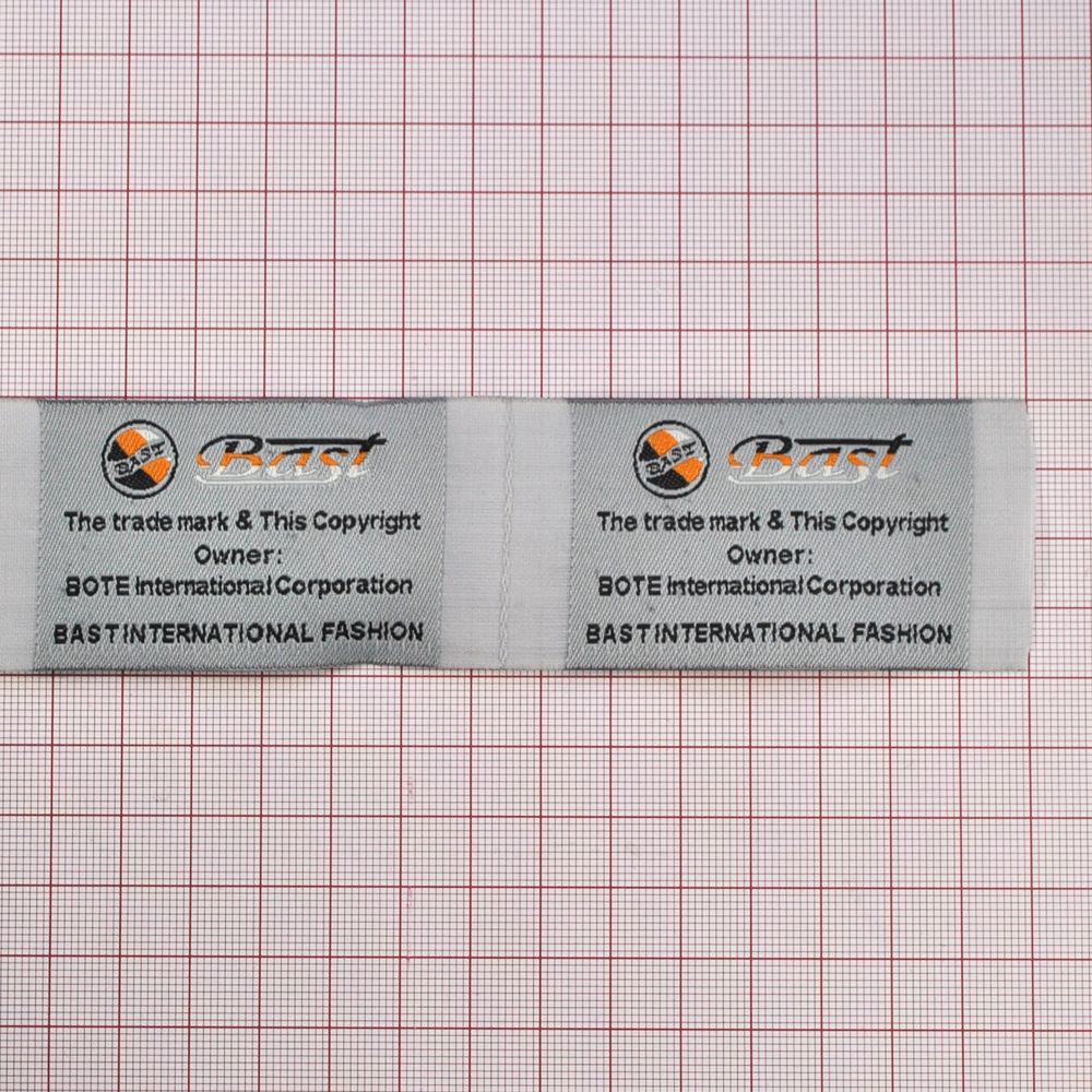 Этикетка тканевая вышитая Bast 4см серая, 100м. Вышивка / этикетка тканевая