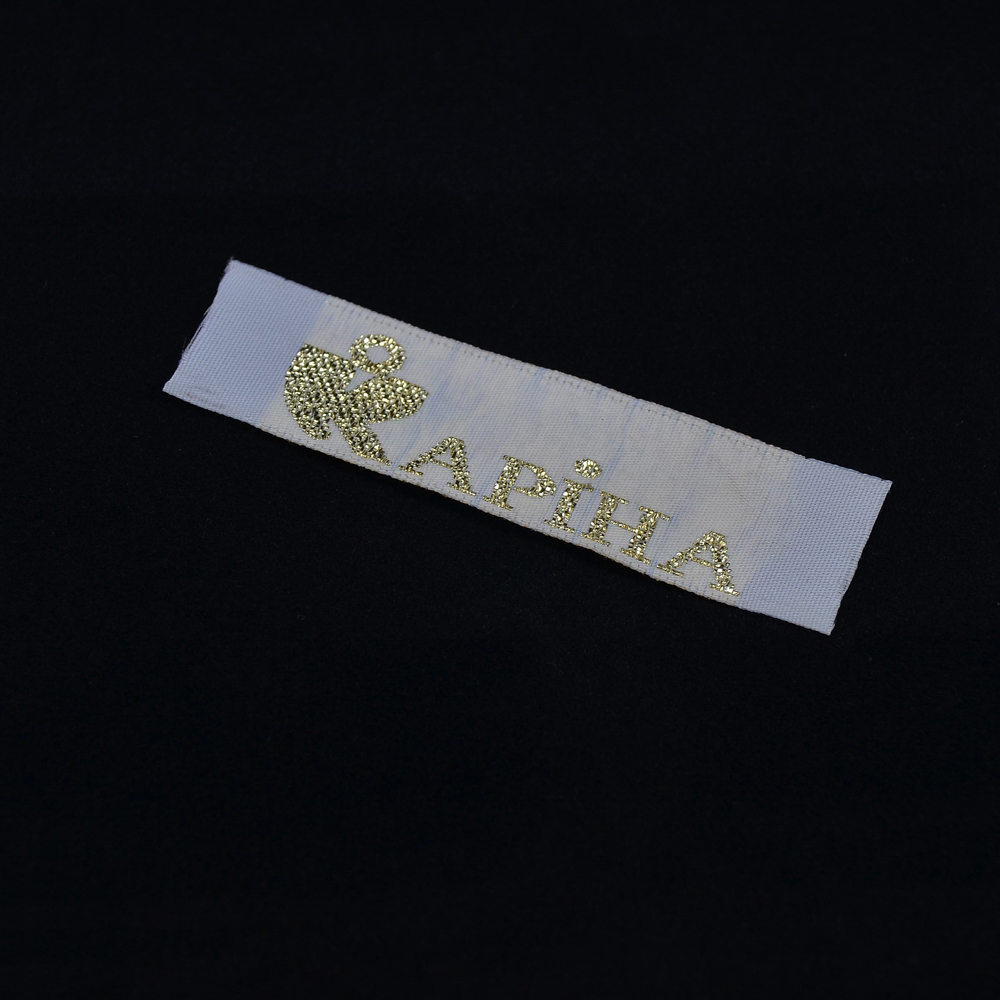 Этикетка тканевая вышитая Карина №1/2см белая с золотом . Вышивка / этикетка тканевая