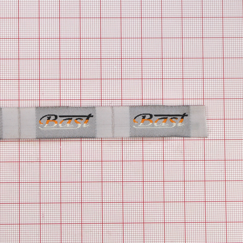 Этикетка тканевая вышитая Bast 1,5см серая 100м. Вышивка / этикетка тканевая