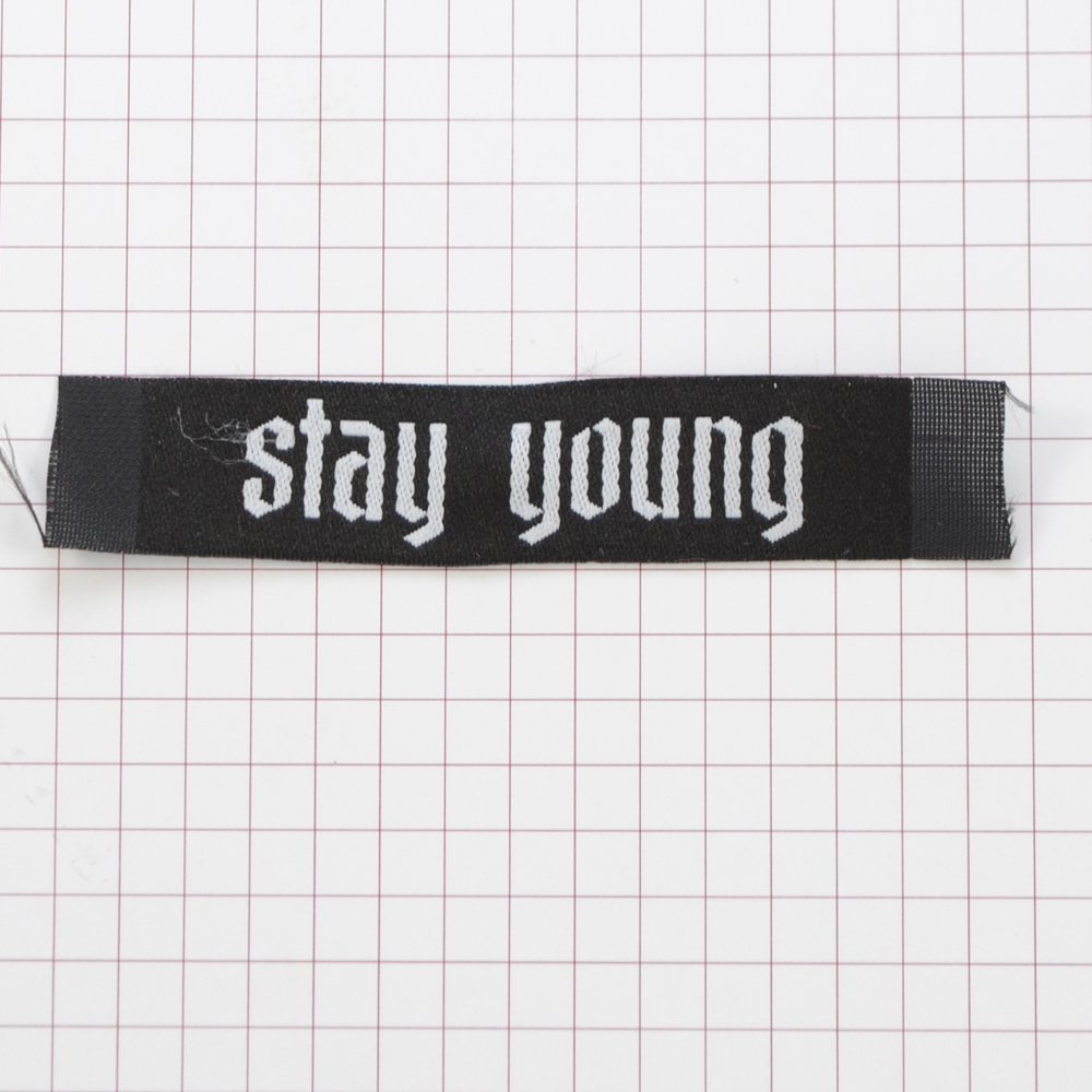 Этикетка тканевая Stay young 1,5см черная и белый лого /70 atki/, шт. Вышивка / этикетка тканевая