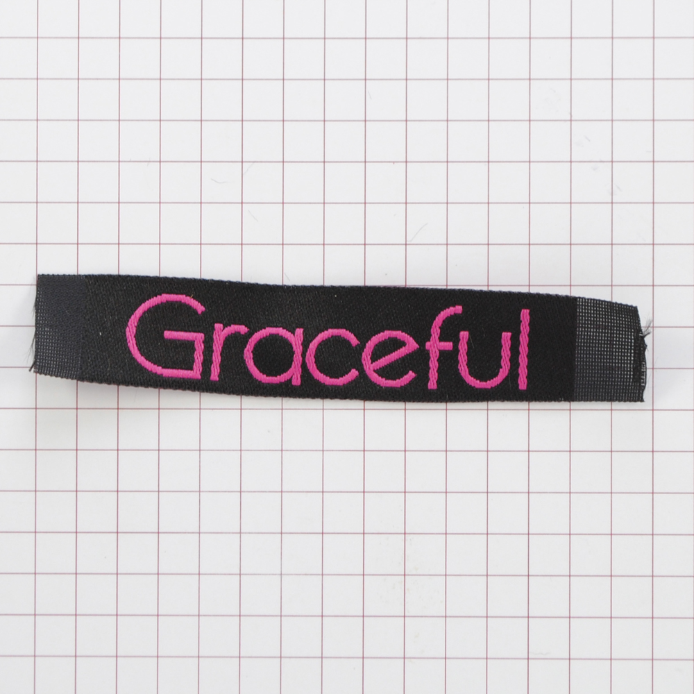 Этикетка тканевая Graceful 1,5см черная и лиловый лого /70 atki/, шт. Вышивка / этикетка тканевая