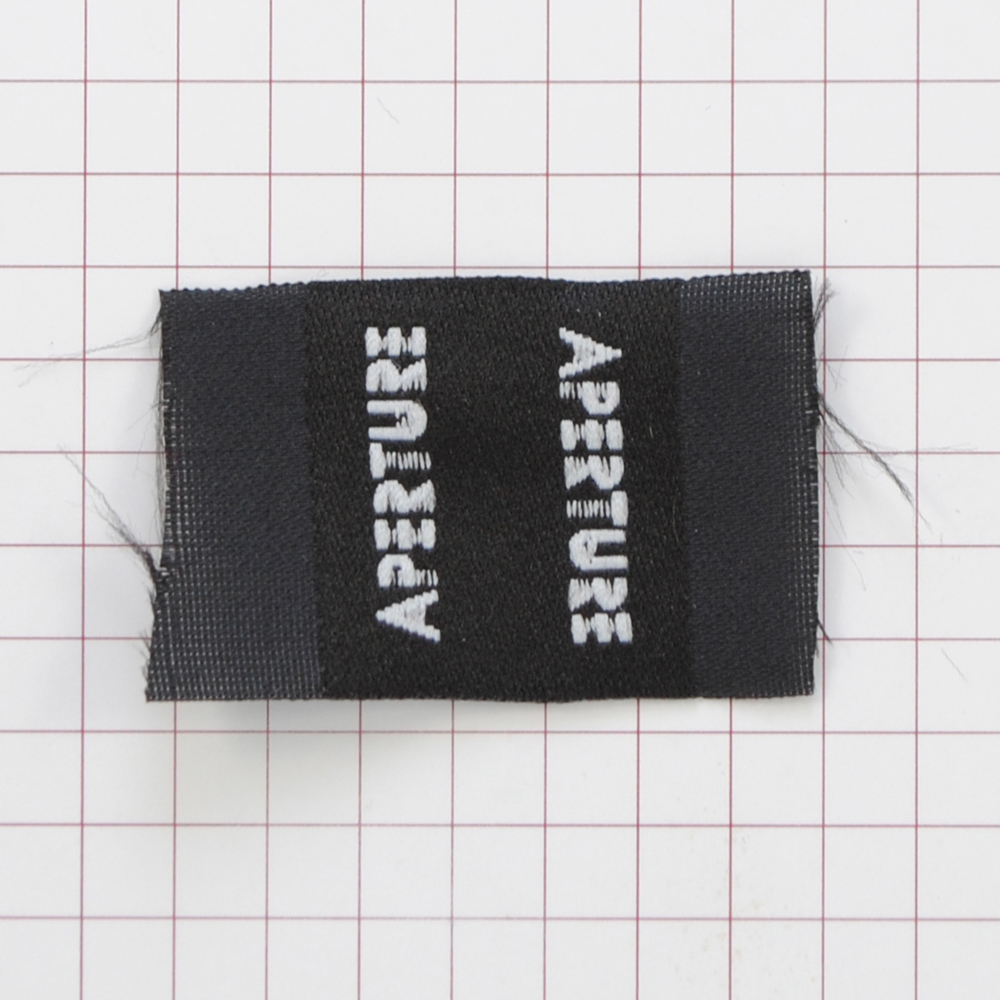 Этикетка тканевая Aperture 2,5см черная и белый лого /флажок, 70 atki/, шт. Вышивка / этикетка тканевая